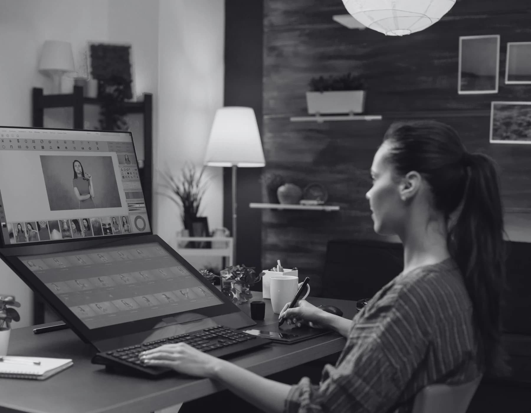 A retoucher editing a model photo across dual monitors.