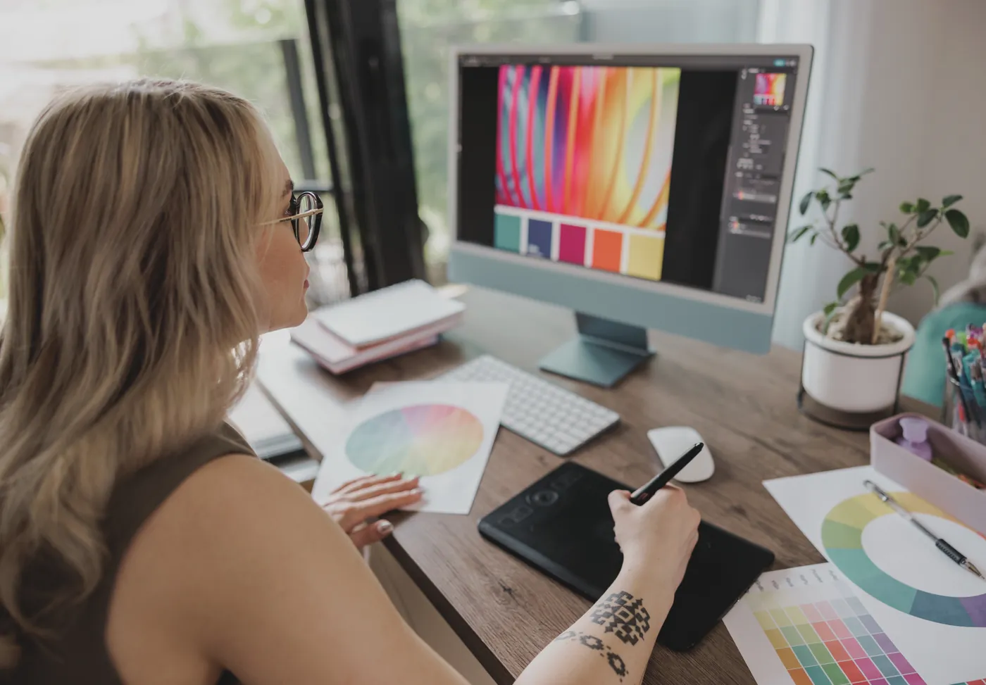 A designer working on colour palettes with a drawing tablet and a colour wheel.
