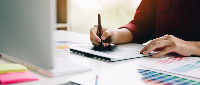 A designer sketching brand marks by hand.