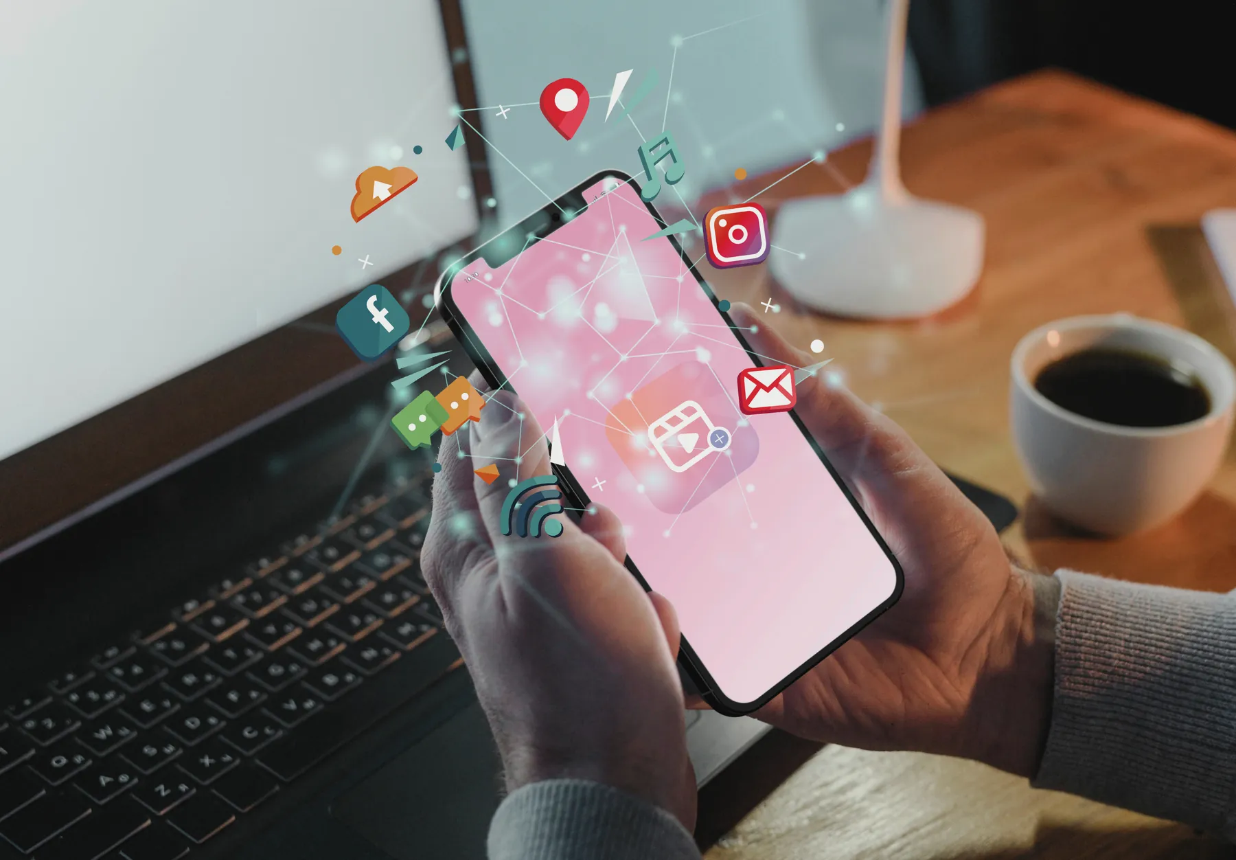 Hands holding a phone with social media app icons floating above it.